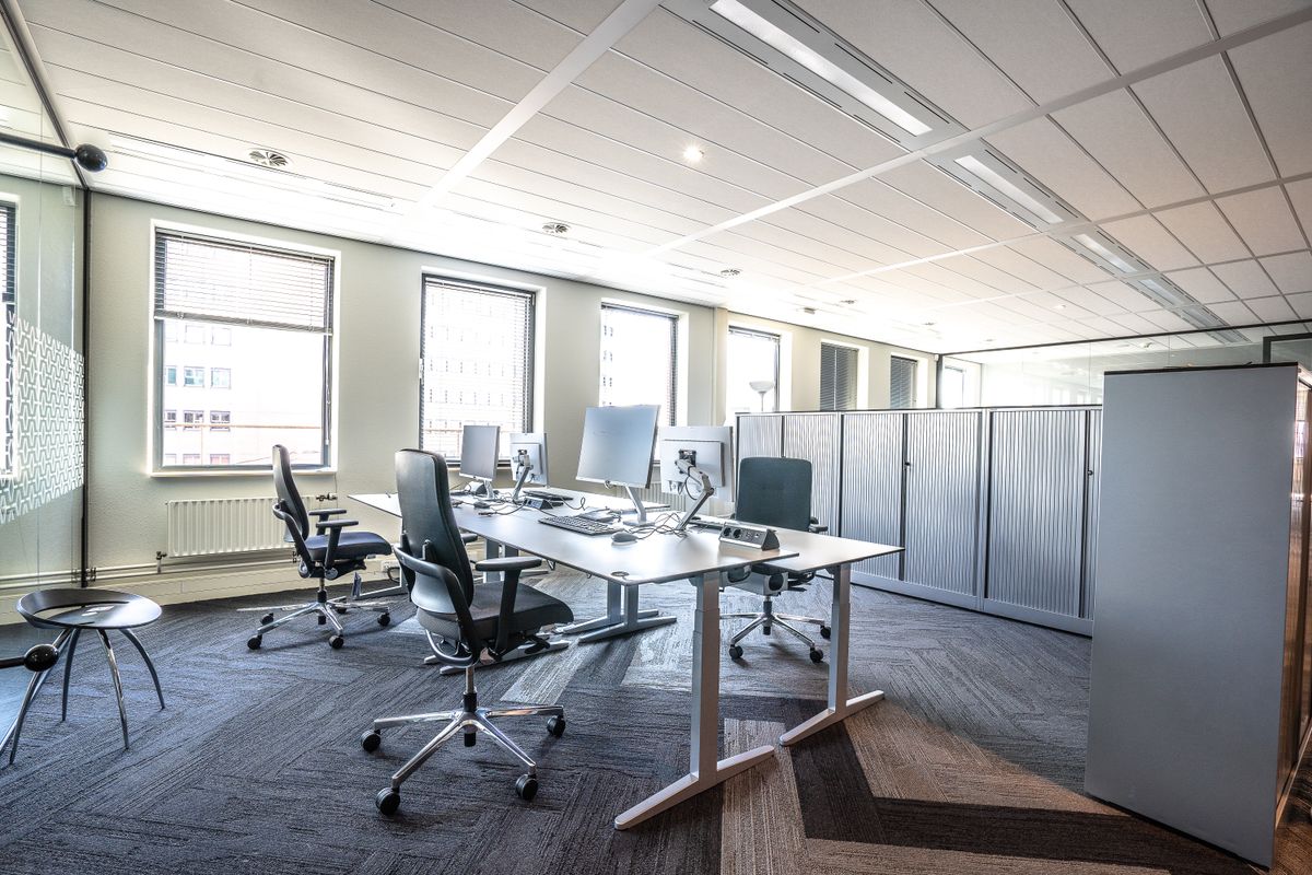 Bright office with shared desks, monitors and chairs ready for cleaning and disinfection