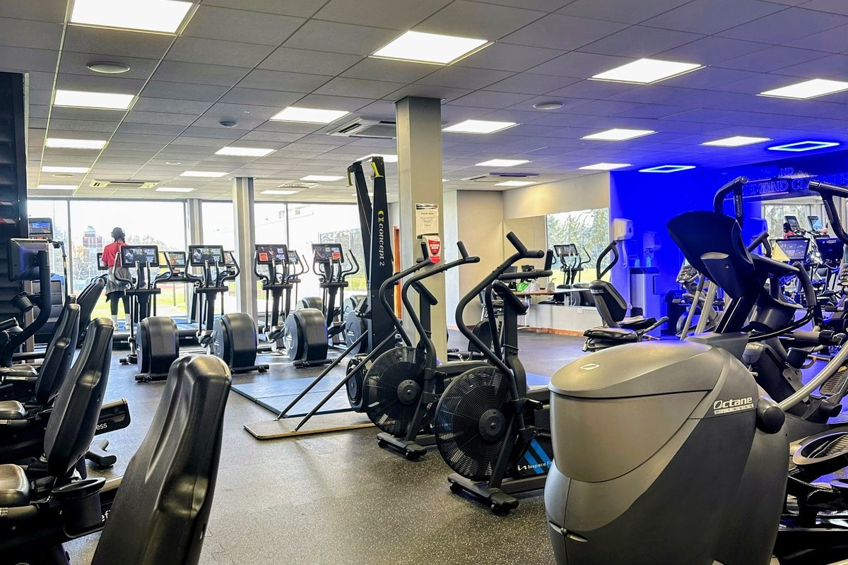 Commercial gym cleaning crew disinfecting fitness equipment in a Charlotte, NC facility