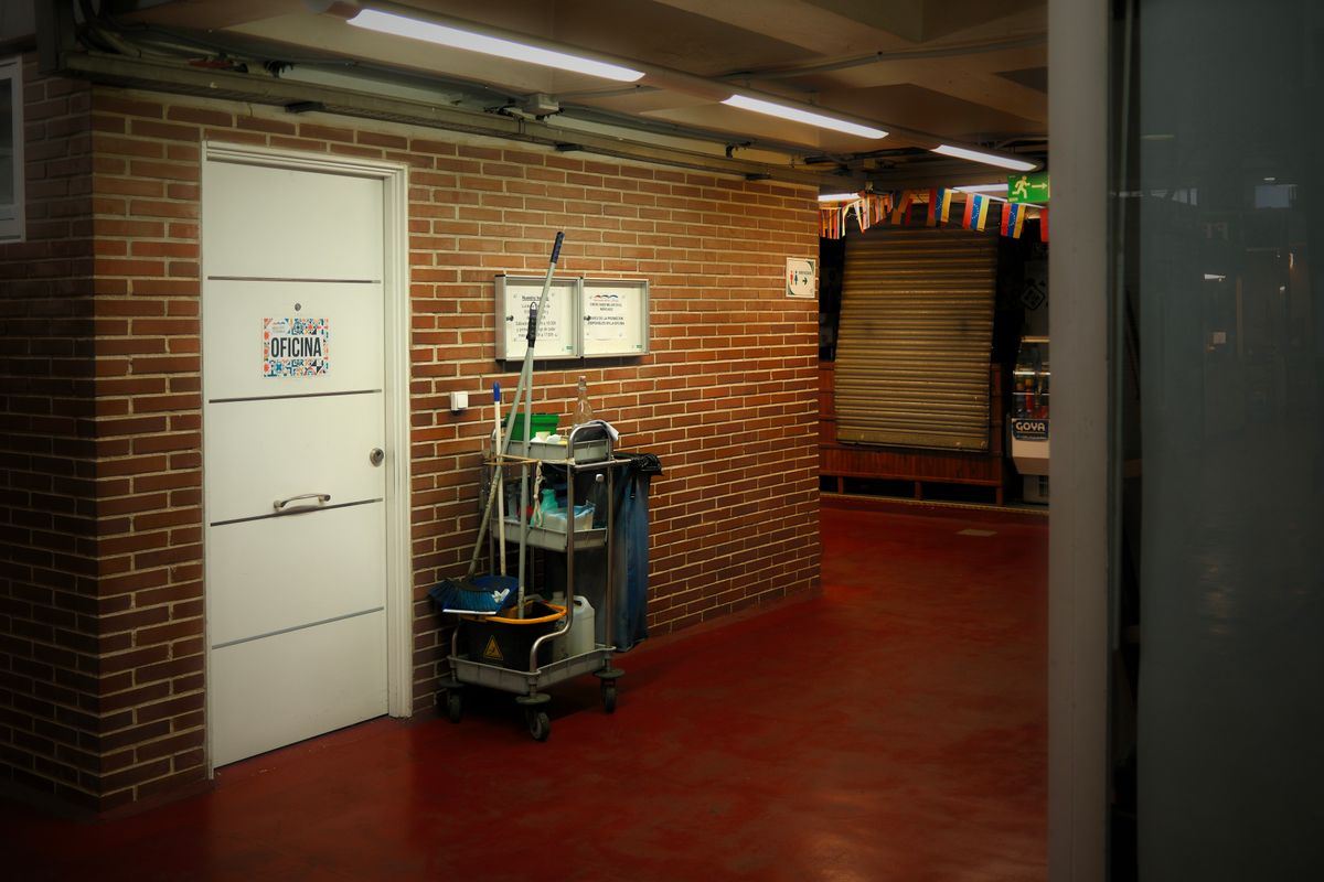 Janitorial cart with cleaning supplies in a commercial building hallway