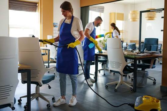 Office cleaning professionals disinfecting workspace
