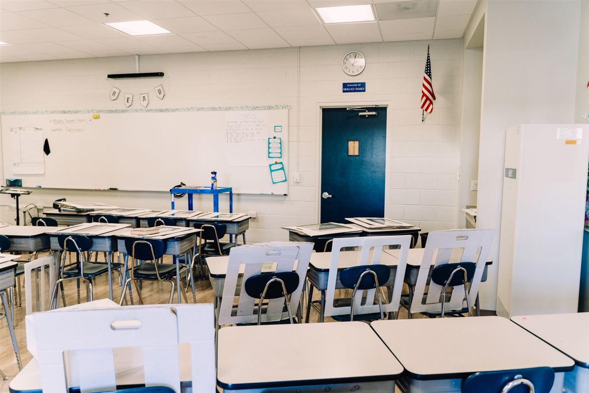 Empty school classroom with desks and a whiteboard